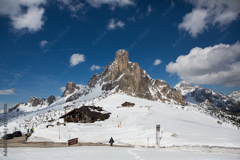Beautiful winter landscape with snow in Alps. Dolomites. Panorama of snow mountain landscape with blue sky. Sunshine. Peaks. Rocks. Alps. Italy.