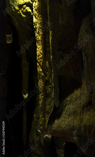 Stalactites in a dark cave with a hard light on top
