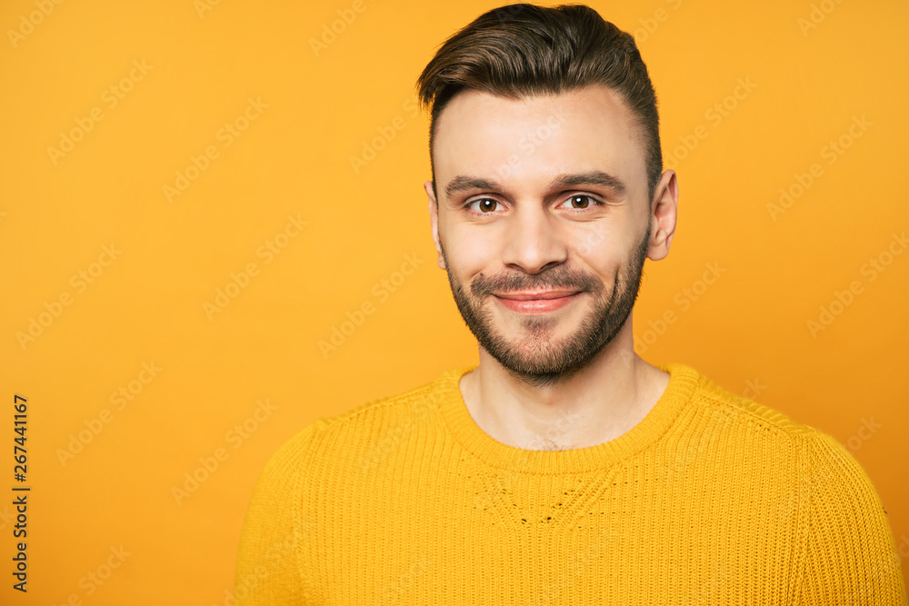 Obraz premium Close up portrait of happy handsome man in yellow is posing over orange background