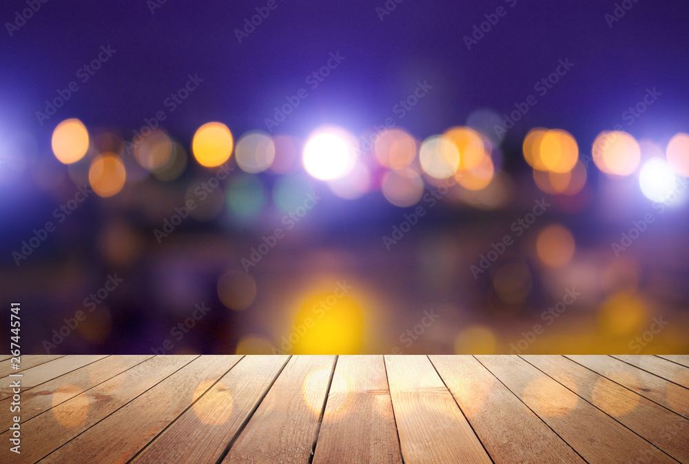 Empty wooden table with blurred cityscape, blurred city lights reflected on wooden background. Empty background template with bokeh