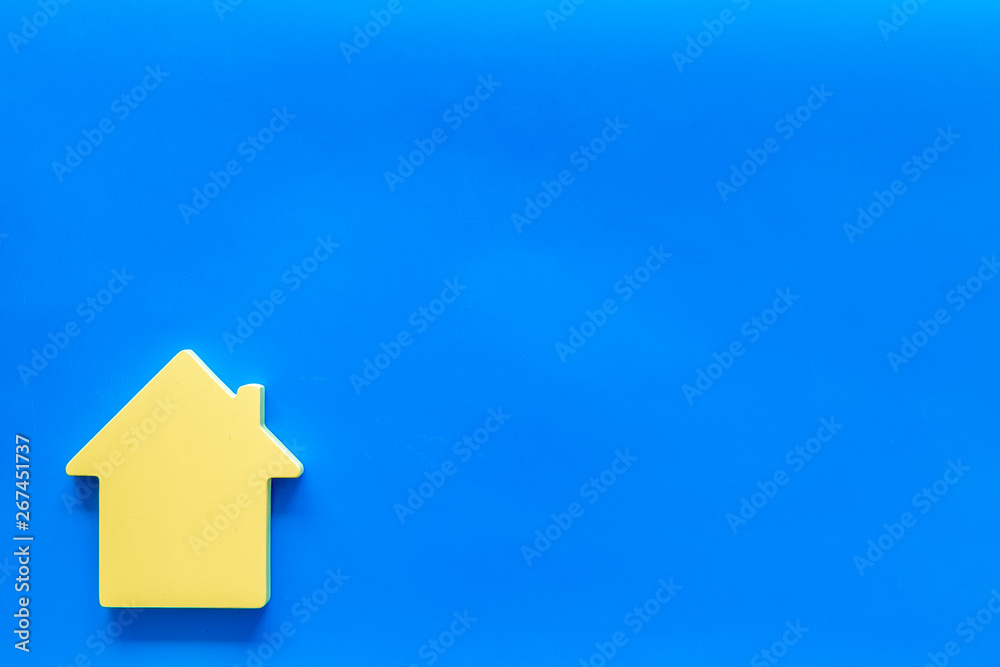 Naklejka premium Mortgage credit concept with house toy on blue background top view copy space