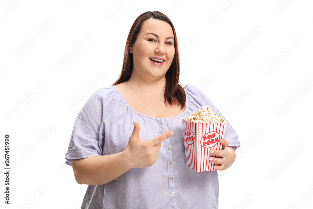 Corpulent young woman holding a box with popcorn and pointing Corpulent young woman holding a box with popcorn and pointing