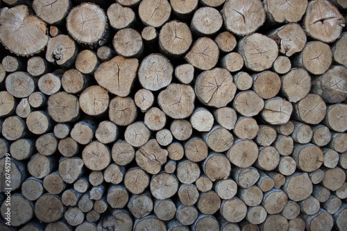 A wall of folded logs in brown and grey. Front view.