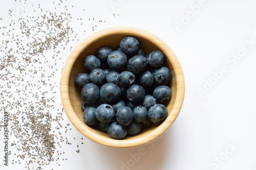 Wooden bowl with blueberries. Decorated with chia seeds. Top view