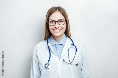 Portrait of a smiling young female doctor in a white coat. 