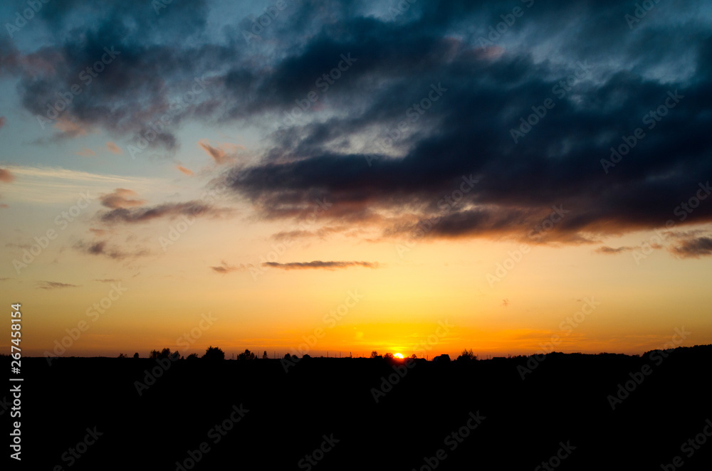 Beautiful sunset under the forest and dark clouds Beautiful sunset under the forest and dark clouds