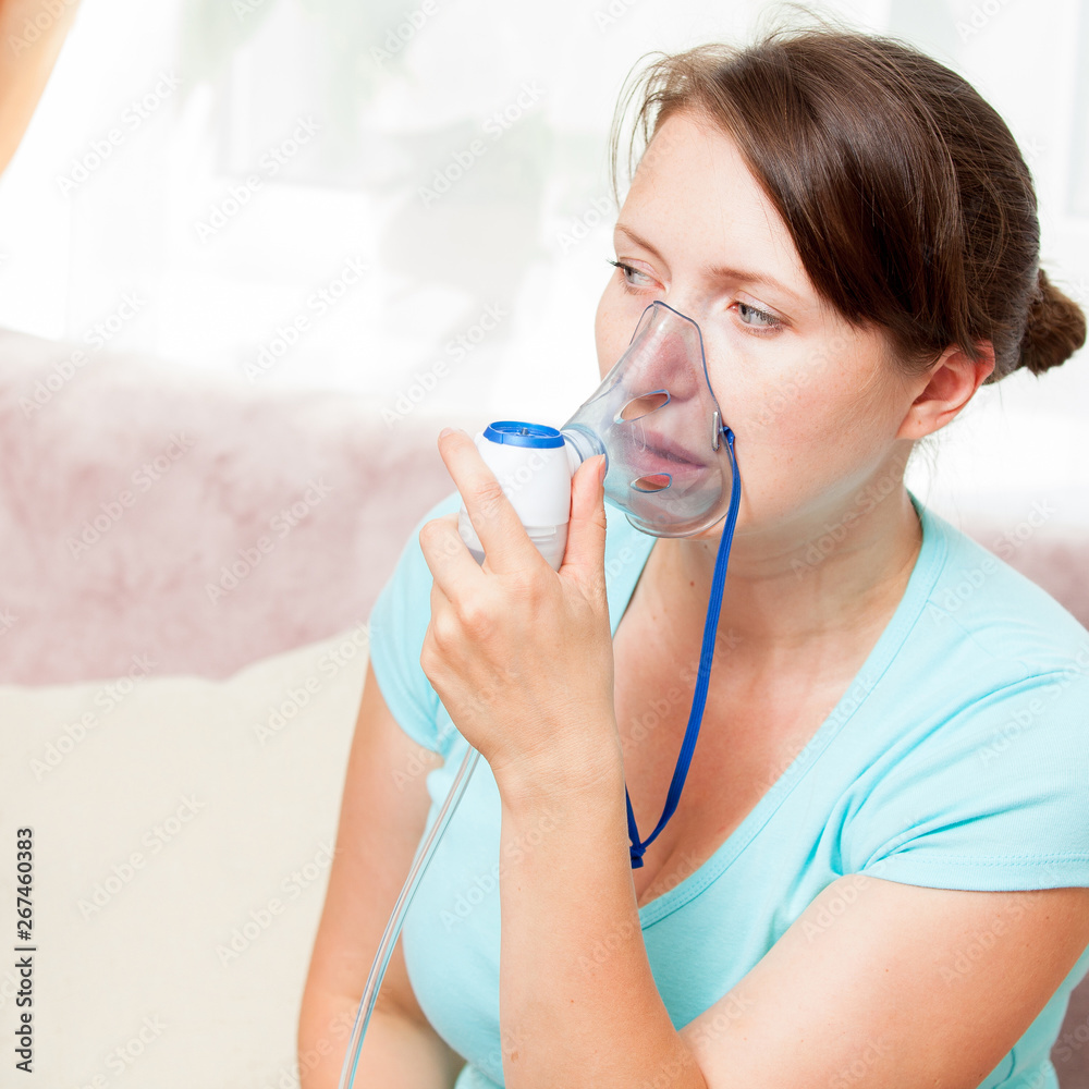 Young woman doing inhalation with a nebulizer at home Young woman doing inhalation with a nebulizer at home
