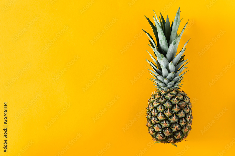 Ripe pineapple on yellow background. Flat lay, top view, copy space