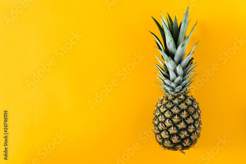 Ripe pineapple on yellow background. Flat lay  top view  copy space
