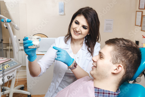 Dentist showing denture to the male patient