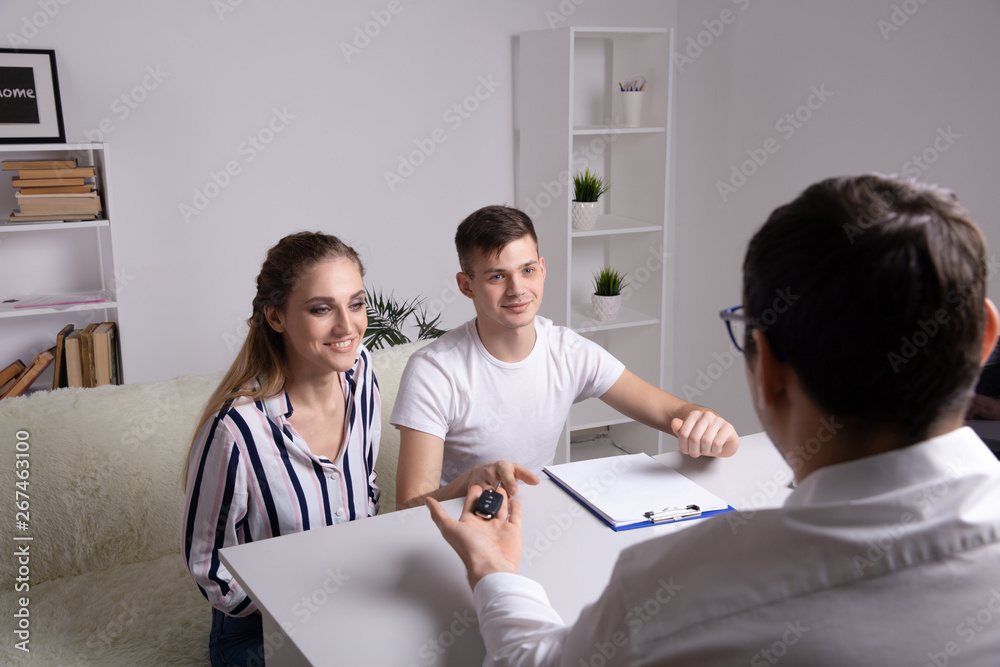 Now her dream comes true. Car salesman giving the key of the new car to