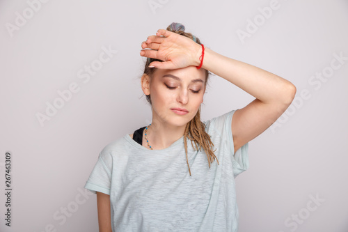 Woman with headache isolated over the grey studio photo