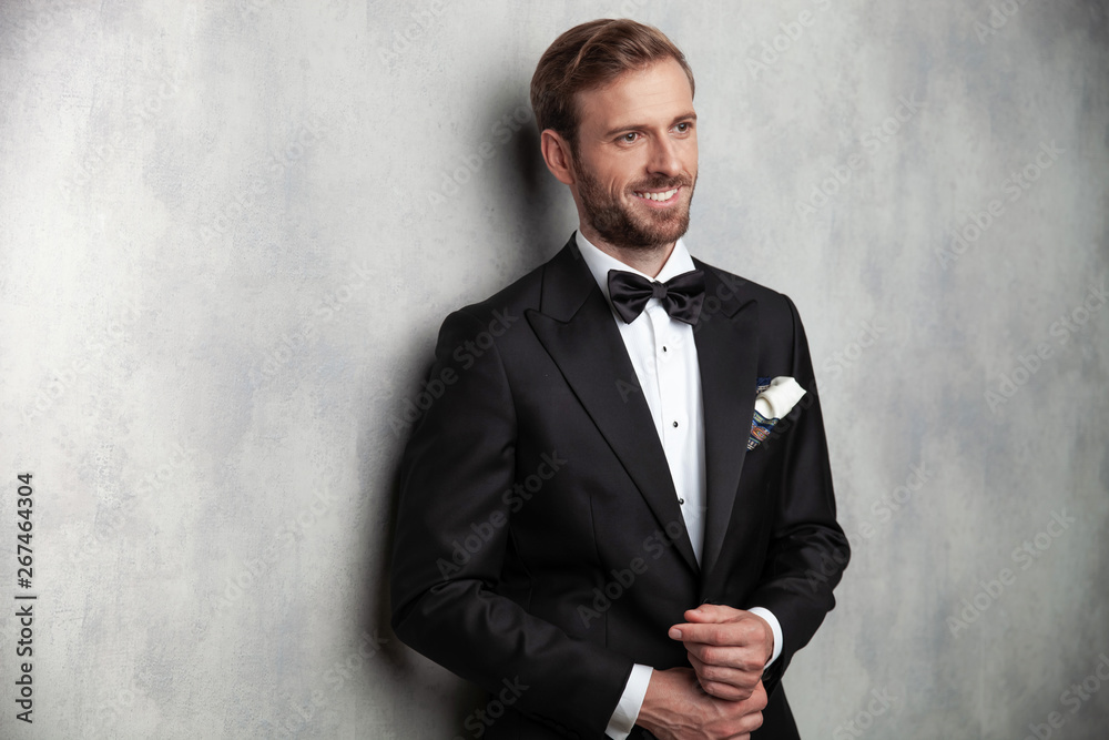 Cheerful groom fixing his sleeves and looking to the side Cheerful groom fixing his sleeves and looking to the side