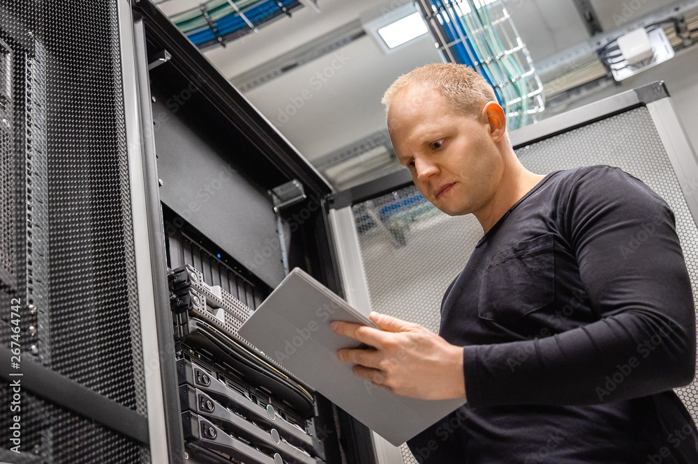 Male IT Professional Using Digital Tablet to Monitor Datacenter Status