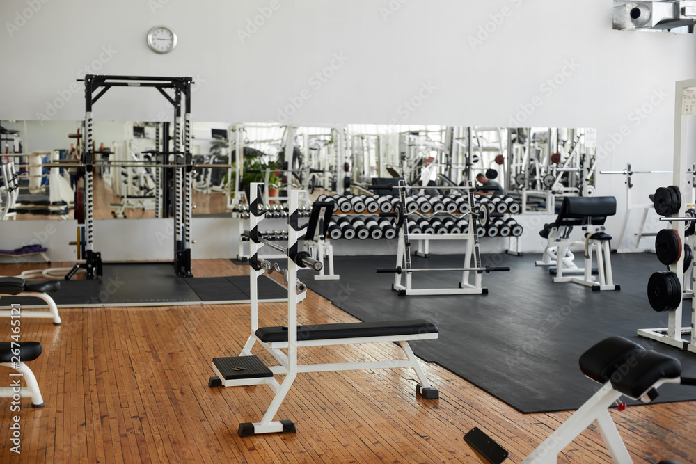 Fototapeta premium Wnętrze siłowni wraz z wyposażeniem. Nowoczesne centrum fitness ze sprzętem treningowym. Projekt wnętrza komercyjnej siłowni.