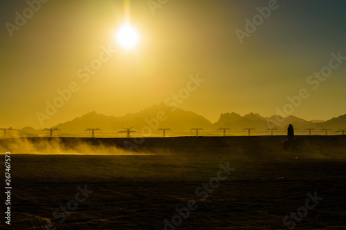 Unrecognizable man driving quad bike during safari trip at sunset in Arabian desert not far from the Hurghada city, Egypt