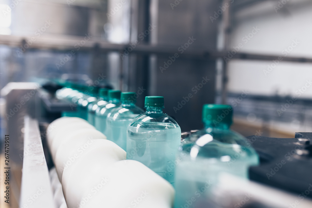 Bottling plant - Water bottling line for processing and bottling pure spring water into small bottles. Selective focus. Bottling plant - Water bottling line for processing and bottling pure spring water into small bottles. Selective focus.