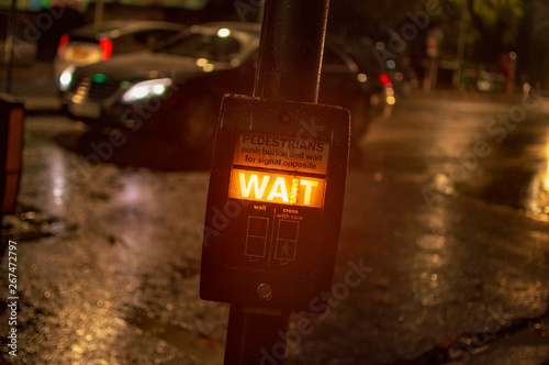 Wait sign box button in london with yellow and orrange illumination in night