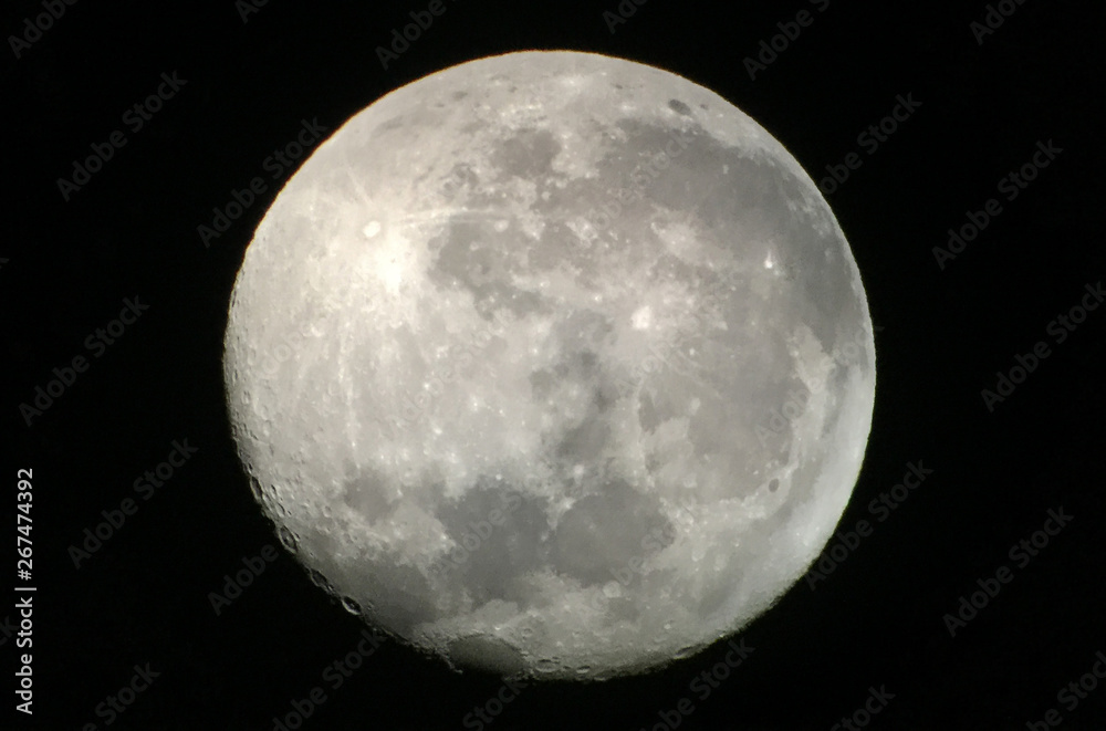 A full moon with visible craters, as seen via a telescope A full moon with visible craters, as seen via a telescope