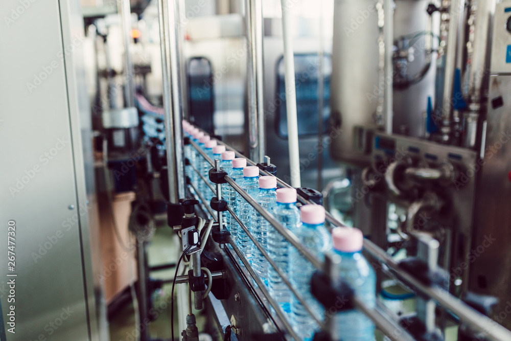 Bottling plant - Water bottling line for processing and bottling carbonated water into bottles. Selective focus.