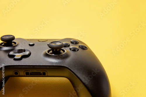 Black joystick gamepad, game console on yellow colourful trendy modern fashion pin-up background. Computer gaming competition videogame control confrontation concept. Cyberspace symbol