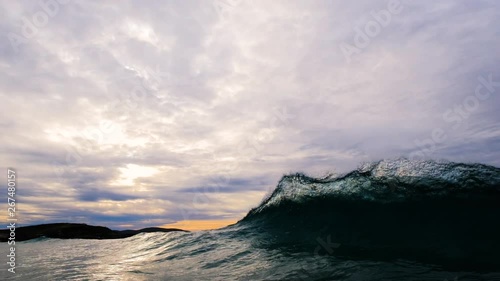 Multiple backwash waves cause several repeated sheets of glassy water to explode upward as wave breaks towards shore.  5x slow motion shot at 120 frames per second and dramatic moody skies and dark gr