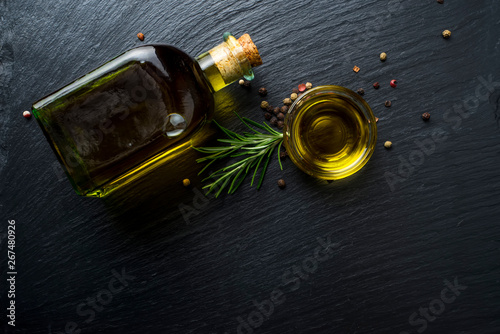 Virgin olive oil in a glass bottle and rosemary