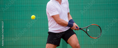 Male tennis player in action on the court