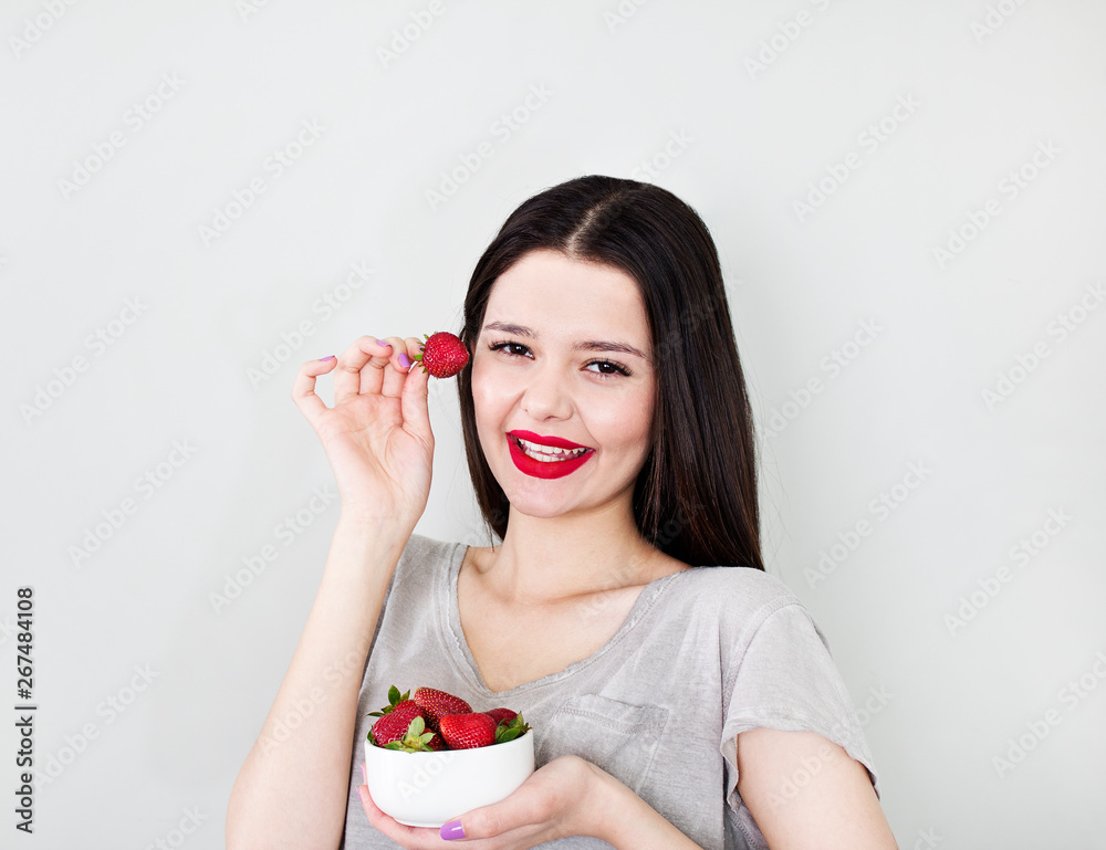 Portrait pretty happy smiling woman with many strawberry over white background Portrait pretty happy smiling woman with many strawberry over white background