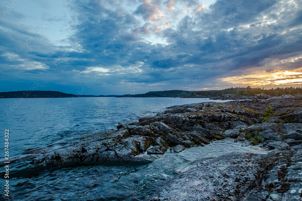 Karelia. Russia. Sunset on lake Ladoga. Ladoga skerries. The waves of Ladoga wash the rocky shore. Northern nature of Karelia. Travelling to Russia.