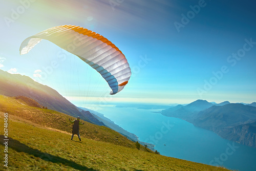 Paraglider flying over the Garda Lake,Panorama of the gorgeous Garda lake surrounded by mountains, Malcesine,Italy