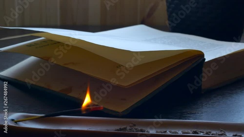 On the table there is an old book and an apical wand that burns after it fades and begins to smoke....