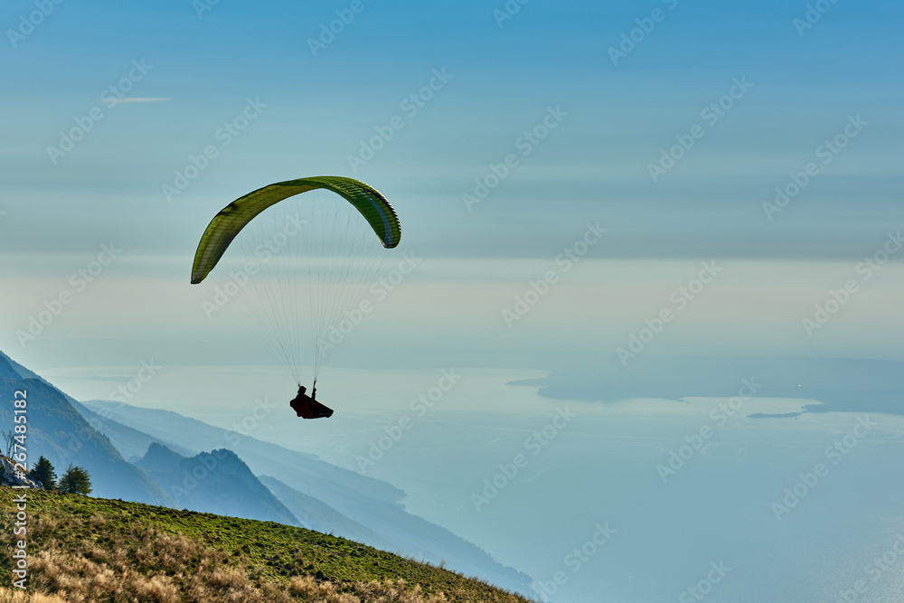 Paraglider flying over the Garda Lake,Panorama of the gorgeous Garda lake surrounded by mountains, Malcesine,Italy Paraglider flying over the Garda Lake,Panorama of the gorgeous Garda lake surrounded by mountains, Malcesine,Italy