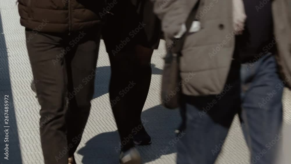 Slow motion shot of a cross-generation crowd crossing the Millennium Bridge in London, England, UK Slow motion shot of a cross-generation crowd crossing the Millennium Bridge in London, England, UK