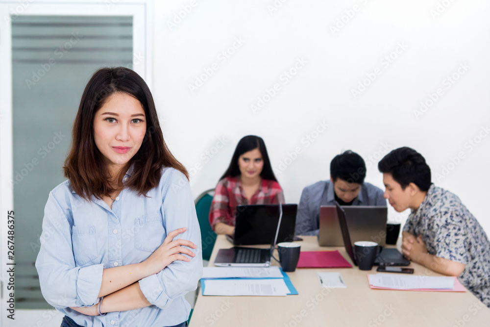 Confident business leader stands with her team Confident business leader stands with her team