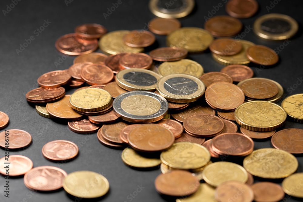 Different amounts of scattered European coins on a black background. Different amounts of scattered European coins on a black background.