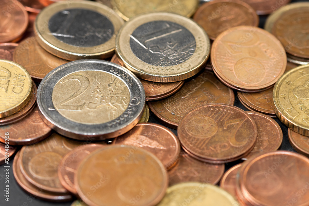 Different amounts of scattered European coins on a black background. Different amounts of scattered European coins on a black background.