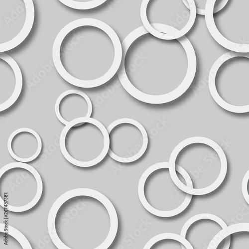 Abstract seamless pattern of randomly arranged white rings with soft shadows on gray background