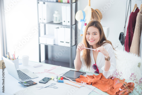 Fotografie Portrait beautiful asian designer woman work with tablet computer in tailer fabric fashion small business shop