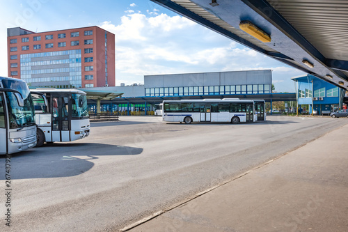 Buses parked near platforms with shelters at bus station