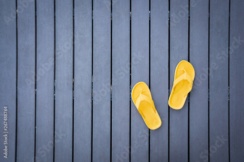 Yellow slippers on dark wooden slats floor