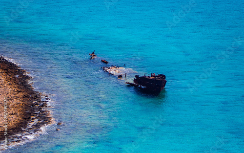 Fototapeta Naklejka Na Ścianę i Meble -  Sunken ship in the shallow blue water