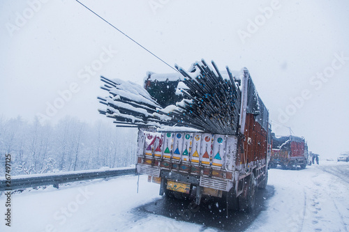 Billede på lærred Winter season harsh bad  weather and snow, Transportation challenge, Truck with