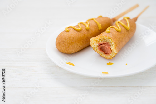 Two corn dogs on white plate