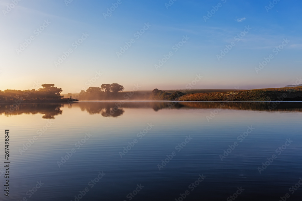 Early morning mist over river at sunrise with copy space