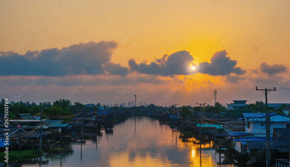 Riverside village with sunset sky and dark clouds, Reflection on the water surface, The sun is shaped like a heart,Bangkok,Thailand-Image