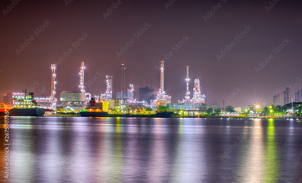 Fototapeta premium Beautiful reflection of Oil refineries located along the river with dark sky background-Image