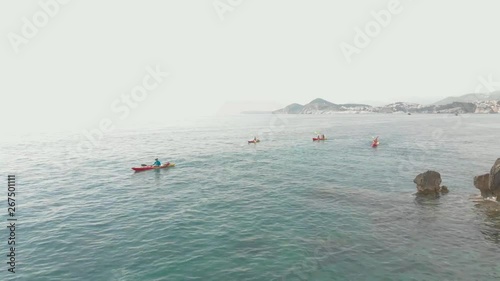 Ocean Kayakers Aerial View. Paddling on the Scenic Ocean Along the Shore. photo