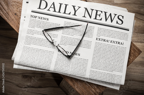 Newspaper with the headline News with glasses on wooden table, Daily Newspaper mock-up concept photo