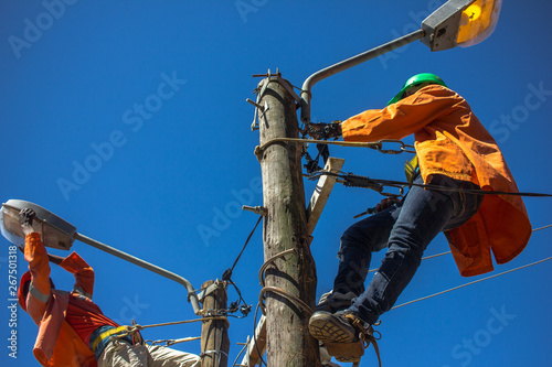 Lineworkers doing maintenance of street lamps in Africa